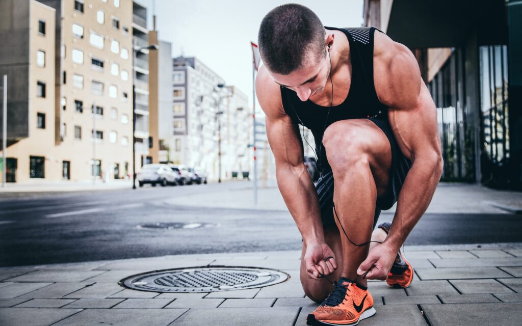 A runner tying his shoe