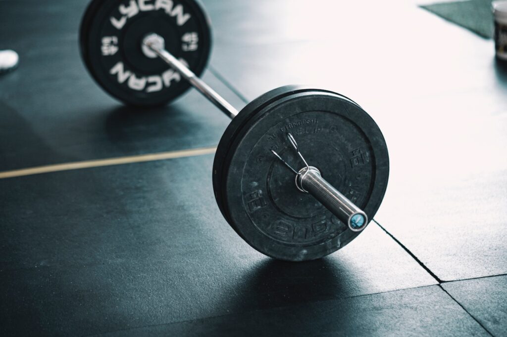 A loaded barbell lying on a gym floor - Best barbells