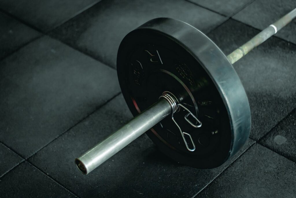 A barbell sleeve with an Olympic weight plate and clip on it