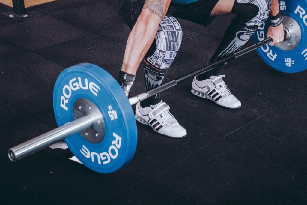 A lifter squatting down and grabbing a barbell
